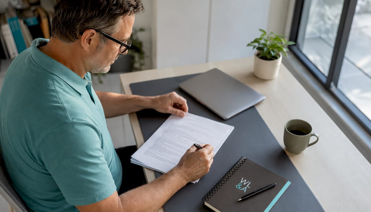 Man reviewing legal property documents at desk
